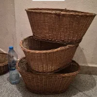 تعدادی سبد حصیری چوبی و گل و گیاه و میوه مصنوعی‌