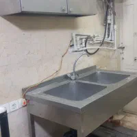 یک عدد سینگ و کابینت استیل و میز شیشه ای