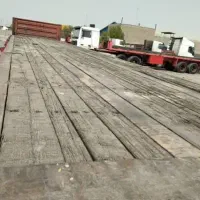 جابجایی حمل بار با تریلی کفی و کمرشکن دو محور