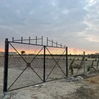 زمین باغی فنس کشی شده با درب ورودی نزدیک بزرگراه