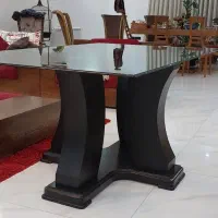 میز غذاخوری شیشه ای  با پایه چوب.