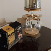 کلمن شیشه ای شامپاینی و شمعدان کنار سالنی