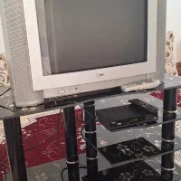 تلویزیون LG همراه با میز و دستگاه دیجیتال.