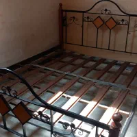 تخت دو نفره با میز آرایش و میز کوچک کنار تخت