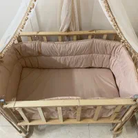 گهواره چوبی کنار تخت مادر