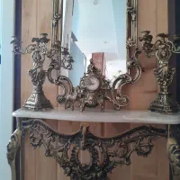 یک عدد آیینه و یک جفت شمعدان و ساعت و کنسول