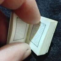 یک جلد قرآن کریم کوچک و بند انگشتی