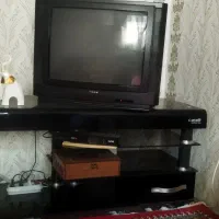 تلویزیون و میز تلویزیون به همراه دستگاه دیجیتال