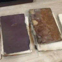 سه جلد کتاب قدیمی و یک جلد روزنامه اطلاعات