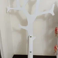 رخت آویزدرختی سفیدرنگ وگلدان زردرنگ