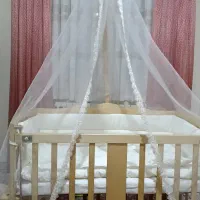 گهواره چوبی کنار تخت مادر