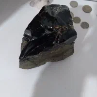 سنگ قدیمی. ابسیدین سیاه و سکه های قدیمی