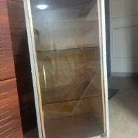 یک عدد کمد چوبی با درب شیشه ای