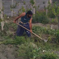 کارگر بیل زنی علف زنی چمن زنی با دستگاه باغبانی