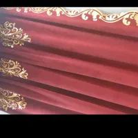 کنار پرده مخمل زرشکی با حاشیه طلایی