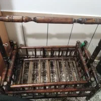 گهواره چوبی و یک چوب لباسی بچه گانه