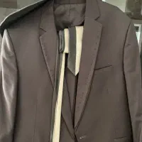 کت شلوار و‌کراوات نو یکساعت پوشیده شده