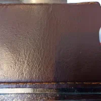 کیف قهوه ای رنگ شامل تعدادی کارت عابربانک