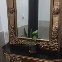 اینه و میز چوبی  و شمعدان فلزی