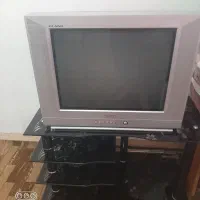 تلوزیون  و میز شیشه ای  و دستگاه دیجیتال