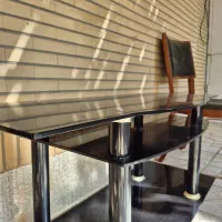 یک عدد  میز تلوزیون فلزی با شیشه های دودی