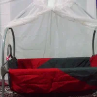 گهواره و تعداد زیادی لباس نوزاد