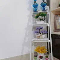 پایه گلدان با گل مصنوعی و چراغ نفتی