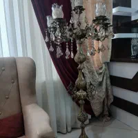 آباژور ایستاده کنار سالنی برنجی مجلل پر نور