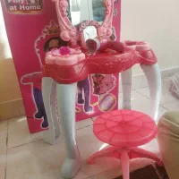 تعدادی اسباب بازی موتور و میز آرایش و تخت عروسک