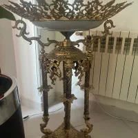 ظرف برنز میوه خوری پایه دار کنار سالنی