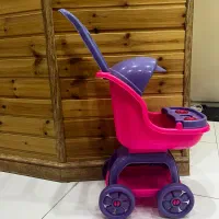 تعدادی اسباب بازی و کالسکه ی عروسک