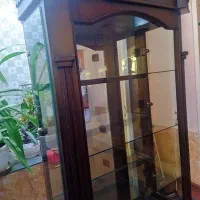 ویترین شیشه ای دارای چهار طبقه شیشه‌ای و پشت آیینه