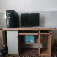 یک دستگاه کامپیوتر همراه با میز کار و لوازم جانبی