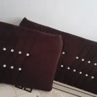 یک جفت پشتی و یک میز تلویزیون قهوه ای