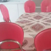 میز شیشه ای و صندلی فلزی با چرم قرمز