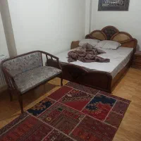 یک تخت خواب چوبی تمیز و دو عدد تشک