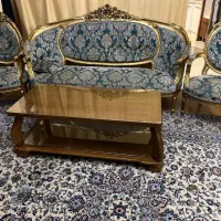 مبل فرهی ۷ نفره همراه با یک میز سنگی گرد.