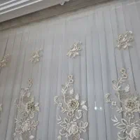 زیر پرده حریر پیله ای سفید روی پرده تور گل برجسته