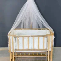 تخت کنار مادر و گهواره چوبی