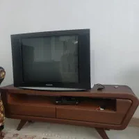 میز تلویزیون شیشه ای و چوبی ویک عدد تلویزیون