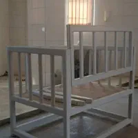 تخت و گهواره نوزاد چوبی کنار تخت مادر