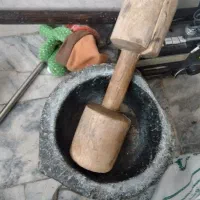 یک آونگ سنگی بسیار قدیمی با دسته چوبی