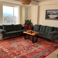 مبل ال ۷نفره رنگش سبزه به همراه دوعدد میز وسط چوبی