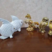 تعدادی مجسمه ماهی سفید وجغد واسب طلایی
