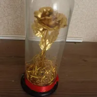 یک عدد گل مصنوی طلای داخل تلق شیشه ای
