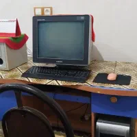 یک دستگاه کامپیوتر قدیمی همراه با میز و صندلی