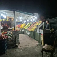 کارگر برای کار در بساط میوه فروشی