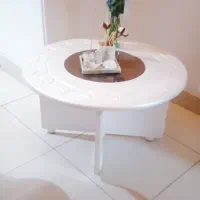 میز سفید رنگ جلو مبلی وسط شیشه