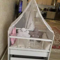 تخت گهواره ای نوزاد کنار مادر