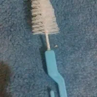 یک برس کوچک شیشه شو و ابخوری قطره ای